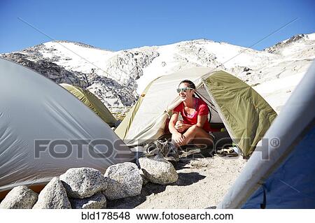 Stock Photo - Hiker sitting in tent at campsite. Fotosearch
