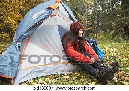 Stock Photo - Hiker sitting in tent at campsite. Fotosearch