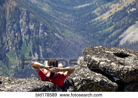 Hiker sitting on rocky hilltop View Large Photo Image Stock Photo - Hiker sitting on rocky hilltop. Fotosearch
