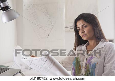 Hispanic architect reading blueprints View Large Photo Image Stock Image - Hispanic architect reading blueprints. Fotosearch