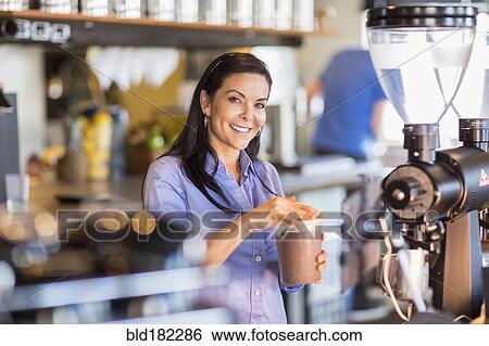 Stock Photograph - Hispanic barista making coffee in cafe. Fotosearch