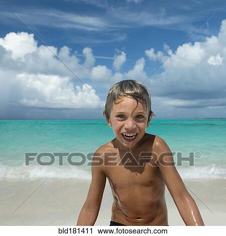 Stock Image - Hispanic boy playing on beach. Fotosearch