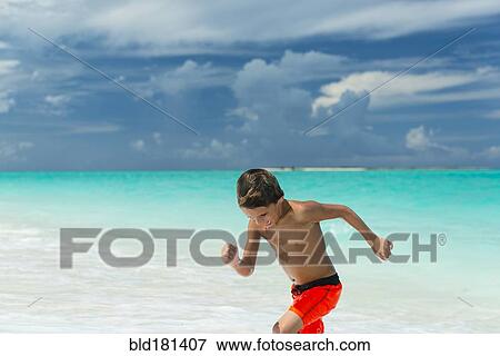 Stock Photo - Hispanic boy playing on beach. Fotosearch