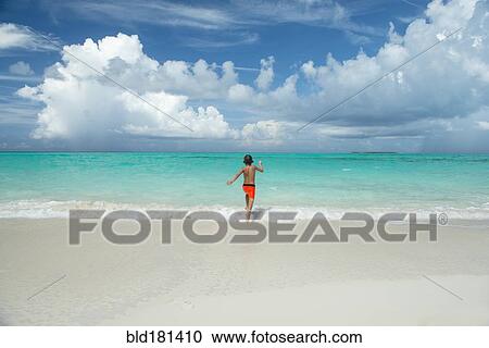 Hispanic boy running in waves on beach View Large Photo Image Stock Image - Hispanic boy running in waves on beach. Fotosearch