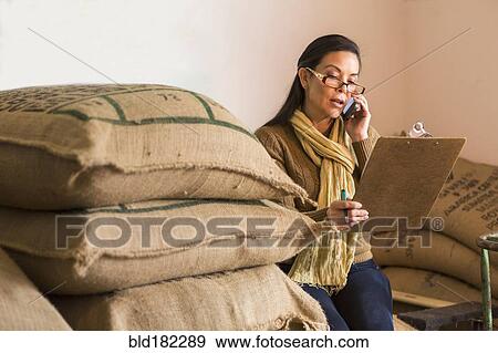 Stock Photo - Hispanic business owner ordering inventory. Fotosearch
