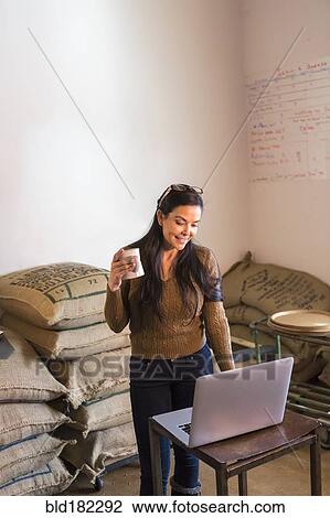 Stock Image - Hispanic business owner working in stock room. Fotosearch