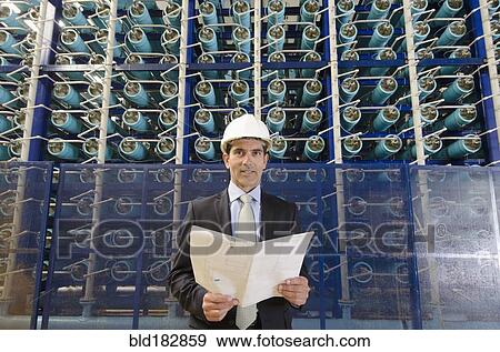 Stock Photo - Hispanic businessman smiling in power plant. Fotosearch