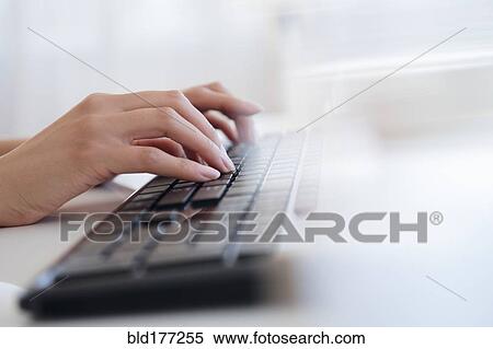 Stock Photography - Hispanic businesswoman typing on keyboard. Fotosearch