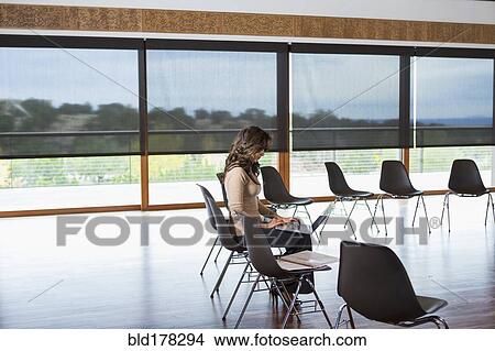 Picture - Hispanic businesswoman using laptop in meeting room. Fotosearch