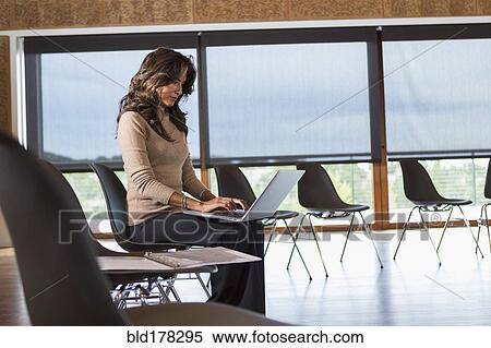 Hispanic businesswoman using laptop in meeting room View Large Photo Image Stock Photography - Hispanic businesswoman using laptop in meeting room. Fotosearch