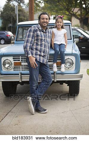 Stock Image - Hispanic father and daughter near truck. Fotosearch