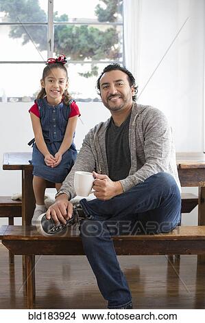 Hispanic father and daughter smiling at table View Large Photo Image Picture - Hispanic father and daughter smiling at table. Fotosearch