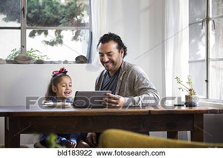 Hispanic father and daughter using digital tablet View Large Photo Image Stock Image - Hispanic father and daughter using digital tablet. Fotosearch