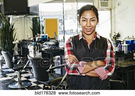 Stock Photo - Hispanic hairstylist smiling in salon. Fotosearch