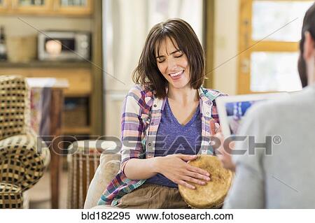 Stock Photography - Hispanic man recording girlfriend playing drums. Fotosearch