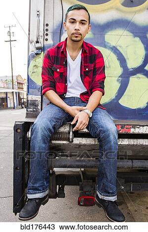 Hispanic man sitting on graffiti truck View Large Photo Image Stock Image - Hispanic man sitting on graffiti truck. Fotosearch