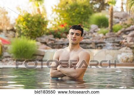 Stock Image - Hispanic man standing in swimming pool. Fotosearch