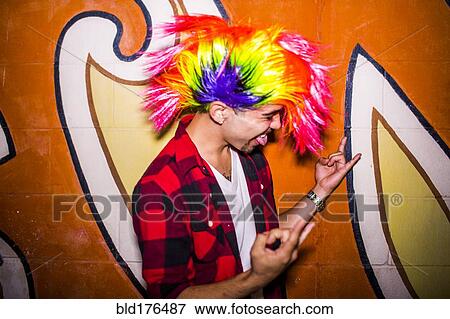 Stock Photo - Hispanic man wearing colorful wig. Fotosearch