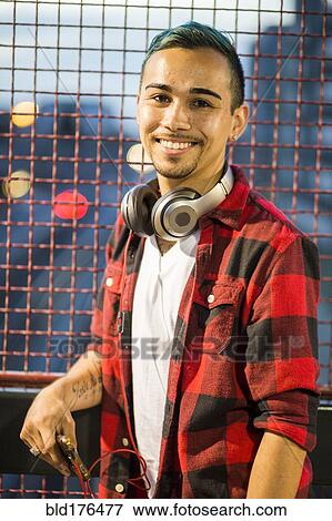 Stock Photo - Hispanic man wearing headphones. Fotosearch