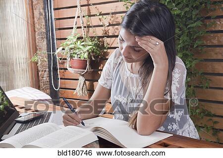 Hispanic student writing at desk View Large Photo Image Stock Photograph - Hispanic student writing at desk. Fotosearch