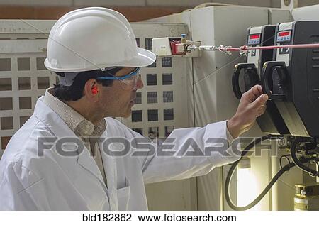 Hispanic technician checking machinery in factory View Large Photo Image Stock Image - Hispanic technician checking machinery in factory. Fotosearch