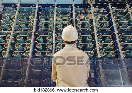 Stock Photograph - Hispanic technician examining power grid infrastructure. Fotosearch