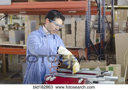 Stock Image - Hispanic technician working in factory. Fotosearch