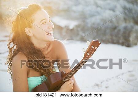 Stock Image - Hispanic teenage girl holding ukulele. Fotosearch