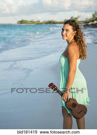 Hispanic teenage girl holding ukulele on beach View Large Photo Image Stock Photo - Hispanic teenage girl holding ukulele on beach. Fotosearch