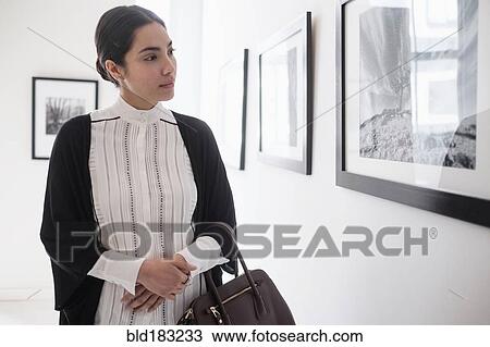 Hispanic woman admiring art in gallery View Large Photo Image Stock Image - Hispanic woman admiring art in gallery. Fotosearch