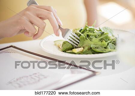 Stock Image - Hispanic woman eating salad. Fotosearch