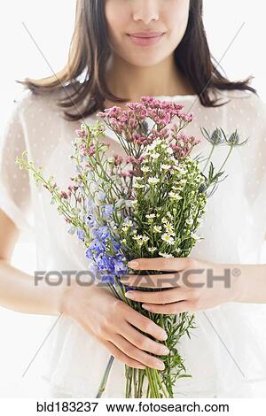 Stock Photo - Hispanic woman holding bouquet of flowers. Fotosearch