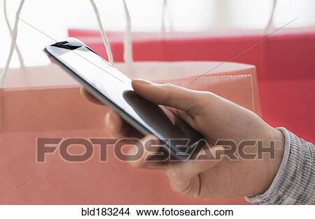 Picture - Hispanic woman holding cell phone. Fotosearch