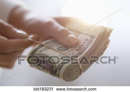 Hispanic woman holding rubber band around wad of cash View Large Photo Image Stock Image - Hispanic woman holding rubber band around wad of cash. Fotosearch
