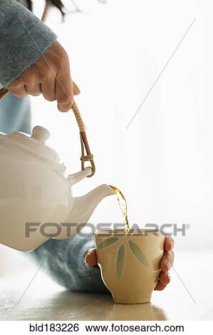 Hispanic woman pouring cup of tea View Large Photo Image Stock Photograph - Hispanic woman pouring cup of tea. Fotosearch