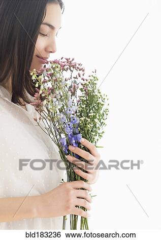 Stock Photograph - Hispanic woman smelling bouquet of flowers. Fotosearch