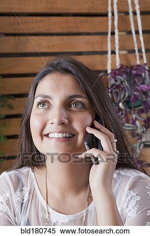 Stock Photography - Hispanic woman talking on cell phone. Fotosearch