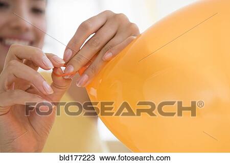 Hispanic woman tying balloon View Large Photo Image Stock Image - Hispanic woman tying balloon. Fotosearch