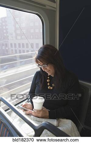 Hispanic woman using cell phone on train View Large Photo Image Stock Image - Hispanic woman using cell phone on train. Fotosearch