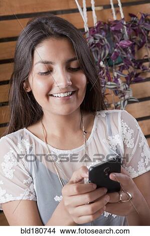 Picture - Hispanic woman using cell phone. Fotosearch
