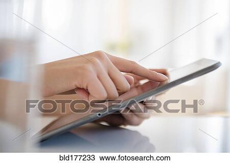Stock Image - Hispanic woman using digital tablet. Fotosearch