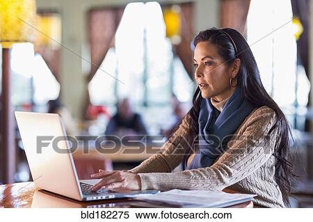 Hispanic woman using laptop in cafe View Large Photo Image Stock Photography - Hispanic woman using laptop in cafe. Fotosearch