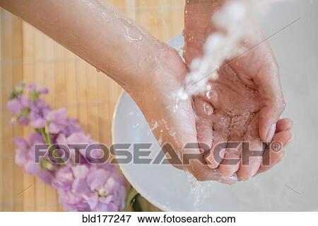 Stock Photo - Hispanic woman washing hands. Fotosearch