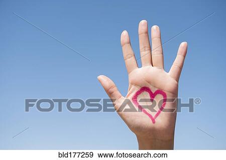 Stock Photo - Hispanic woman with heart on hand. Fotosearch