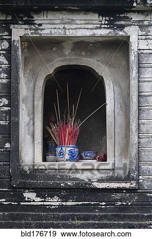 Stock Photo - Incense in wall alcove shrine of Buddhist temple. Fotosearch