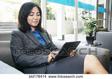 Picture - Japanese businesswoman using digital tablet in office. Fotosearch