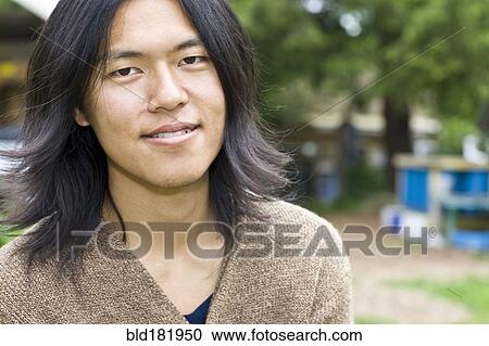 Stock Image - Japanese man smiling outdoors. Fotosearch