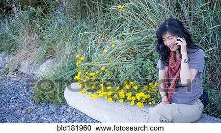 Japanese woman talking on cell phone outdoors View Large Photo Image Stock Image - Japanese woman talking on cell phone outdoors. Fotosearch