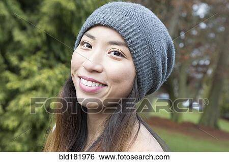 Stock Photograph - Japanese woman wearing beanie outdoors. Fotosearch