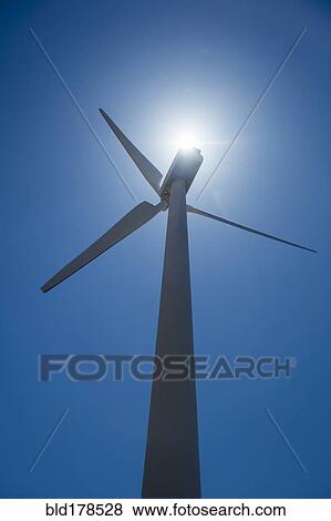 Stock Photo - Low angle view of wind turbine and blue sky. Fotosearch